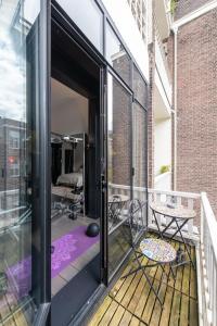 阿姆斯特丹Museum Square View B&B的通往带桌椅的阳台的开放式门