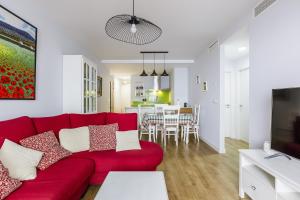 托雷德尔马尔A&N Margarita的一间带红色沙发的客厅和一间用餐室