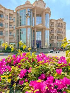 开罗Ramage Hotel & Resort的一座大建筑前面有粉红色的花朵