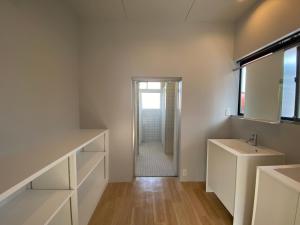 壹岐市ikibase Guest House的白色的浴室设有水槽和镜子