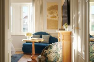 马德里The Westin Palace, Madrid的客厅配有蓝色的沙发和桌子