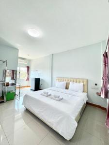 Ban Wang Phai Tha Khamโรงแรม ปาล์มเพลส的卧室配有白色床单和白色大床