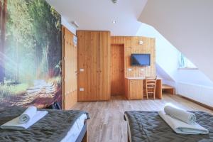 Podjelje伯祖卡耶尔卡酒店的一间设有两张床和一台电视的房间