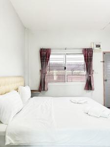 Ban Wang Phai Tha Khamโรงแรม ปาล์มเพลส的卧室配有白色的床和窗户。