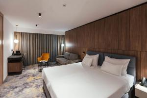 杜布罗夫尼克City Hotel Dubrovnik的酒店客房设有一张大床和一张书桌。
