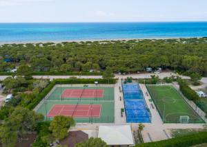 乌真托Riva di Ugento Beach Camping Resort的享有两个网球场和海滩的顶部景色