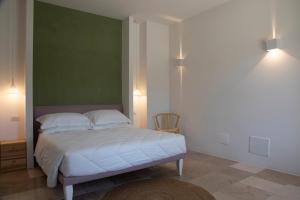 圣塞韦罗Masseria Celentano Relais & Agriturismo的一间卧室配有一张带绿色墙壁的床