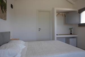 圣塞韦罗Masseria Celentano Relais & Agriturismo的一间带白色床的卧室和一间厨房