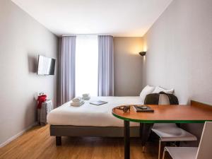 迈松阿尔福巴黎迈松阿尔福阿德吉奥阿克瑟斯公寓式酒店的酒店客房配有一张床铺和一张桌子。