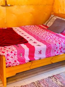 努韦巴New Mabroka的一张木床,上面有粉色和白色的被子
