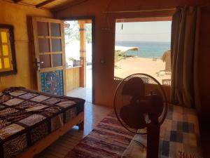 努韦巴New Mabroka的一间卧室配有一张床,享有海滩美景