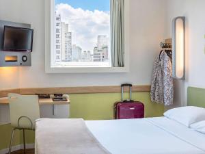 圣保罗ibis budget Sao Paulo Jardins的酒店客房设有床和窗户。