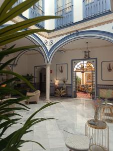 塞维利亚唐佩德罗宫酒店的拥有蓝色和白色天花板的建筑的大堂