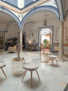 塞维利亚唐佩德罗宫酒店的大楼内带桌椅的房间