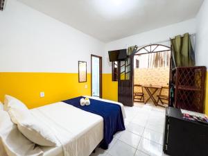 莫罗圣保罗Pousada Sol e Mar的一间卧室设有一张床和黄色的墙壁