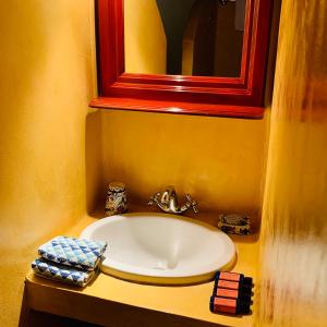 迈伊斯蒂Mediterraneo Hotel的一间带水槽和红色镜子的浴室