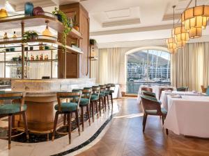 开普敦Cape Grace, A Fairmont Managed Hotel的餐厅设有酒吧,配有桌椅