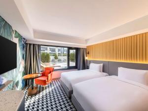 首尔蒙德里安首尔梨泰院街酒店的酒店客房设有两张床和窗户。