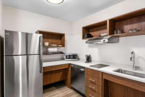 列克星敦Everhome Suites Lexington North的厨房配有不锈钢冰箱和木制橱柜