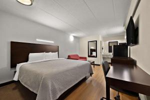 皮奥里亚Suburban Studios Peoria的配有一张床和一张书桌的酒店客房