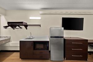 皮奥里亚Suburban Studios Peoria的带冰箱的厨房和平面电视。