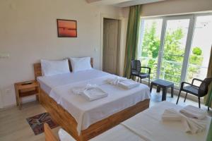 埃杰阿巴德Eceabat Doğa Pansiyon-Hotel的一间卧室设有一张大床和一个大窗户