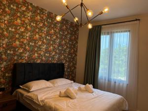 巴统Feel Georgia的一间卧室配有一张带花卉壁纸的大床