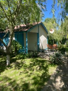 穆里吉奥尔Popas Turistic Alex的院子中带桌子和长凳的蓝色房子