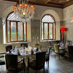 马拉喀什红房子酒店的一间带桌椅和吊灯的用餐室