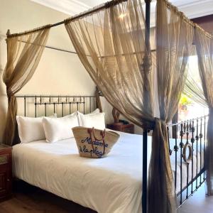 马拉喀什红房子酒店的一间卧室配有一张带枕头的天蓬床