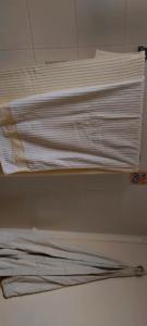 皮索利瓦迪Καραμπεικο的一堆白色衬衫放在房间里架子上