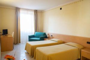 Villanova dʼAstiAlbergo del muletto的酒店客房,设有两张床和一张蓝色椅子