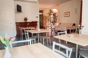 Villanova dʼAstiAlbergo del muletto的餐厅设有木桌、椅子和电视。