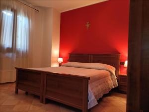 托里诺迪桑格罗Il Melograno的一间卧室配有一张红色墙壁的床