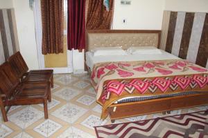 帕拉姆普尔Hotel Union And Restaurent的一间卧室配有一张床和一把椅子
