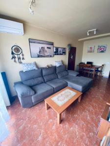 AlgaidaCompleta y Amplia Habitación a 10 minutos de la playa Casa Compartida的客厅配有蓝色的沙发和桌子