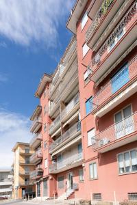 基奥贾SUN House的粉红色的公寓楼设有阳台