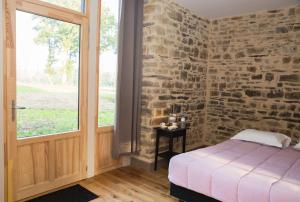 MaxentDomaine des Hayes的卧室设有砖墙、床和窗户