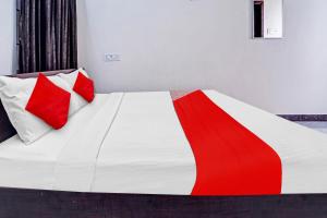 NāmakkalSuper OYO Flagship Royal Residency的一张带两个红色和白色枕头的床