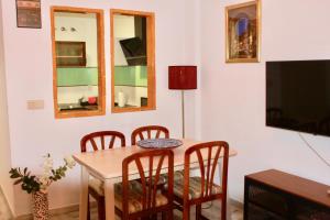 塞内斯德拉韦加Apartamentos Vado - Ruta de la Sierra的一间带桌椅和电视的用餐室