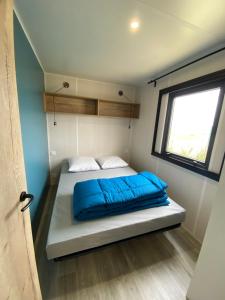 多吕多勒龙Camping Ostréa ****的一个小房间的一个床位,设有窗户