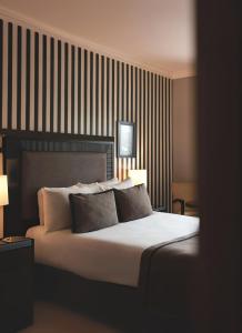 伊斯坦布尔塔克西姆阿旺嘉德酒店的一间卧室配有一张大床和两个枕头
