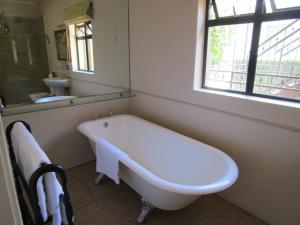 开普敦露斯汀旅馆的带窗户的浴室内的白色浴缸