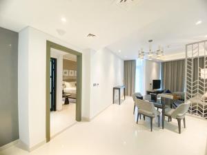 迪拜Comfy 1BR in Damac Maison Prive by Huaxia Homes的用餐室以及带桌椅的起居室。