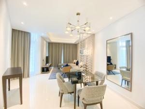 迪拜Comfy 1BR in Damac Maison Prive by Huaxia Homes的用餐室以及带桌椅的起居室。