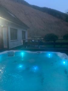 史宾桥Captivating 5-Bed Cottage with private hot tub的一座房子前方的蓝色灯光游泳池