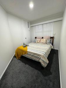 奥克兰Auckland airport holiday home的一间卧室配有一张带黄色毯子的大床
