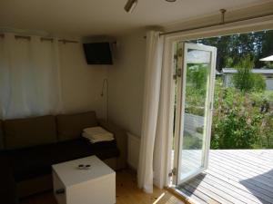 LjugarnKleines Ferienhaus - Tiny house - auf Gotland 700 Meter zum Meer的带沙发和滑动玻璃门的客厅