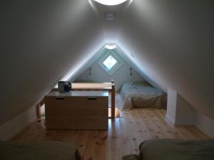 LjugarnKleines Ferienhaus - Tiny house - auf Gotland 700 Meter zum Meer的阁楼间配有书桌和两张床