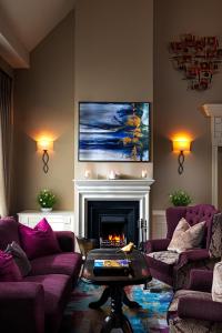 西纽卡斯尔Longcourt House Hotel的客厅配有紫色沙发和壁炉
